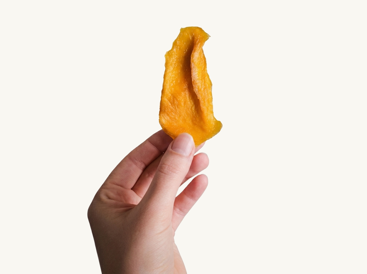 o felie de mango în mână