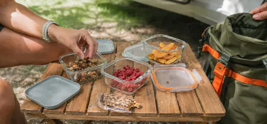 Cutii deschise cu nuci, fructe liofilizate și gustări în camping