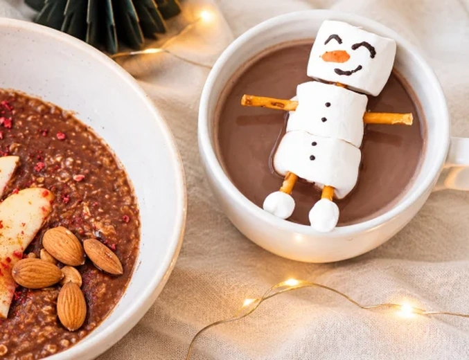 O cană de cacao fierbinte cu un om de zăpadă din marshmallow